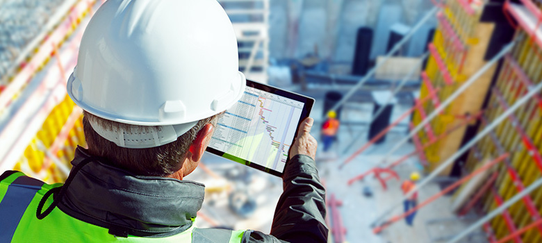 Engineer checks inquiries and tenders on the construction site using a tablet